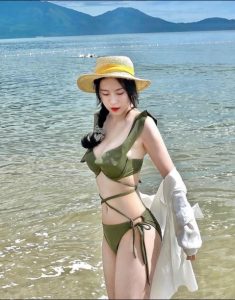 Người đẹp với bộ bikini màu xanh rêu bên bãi biển